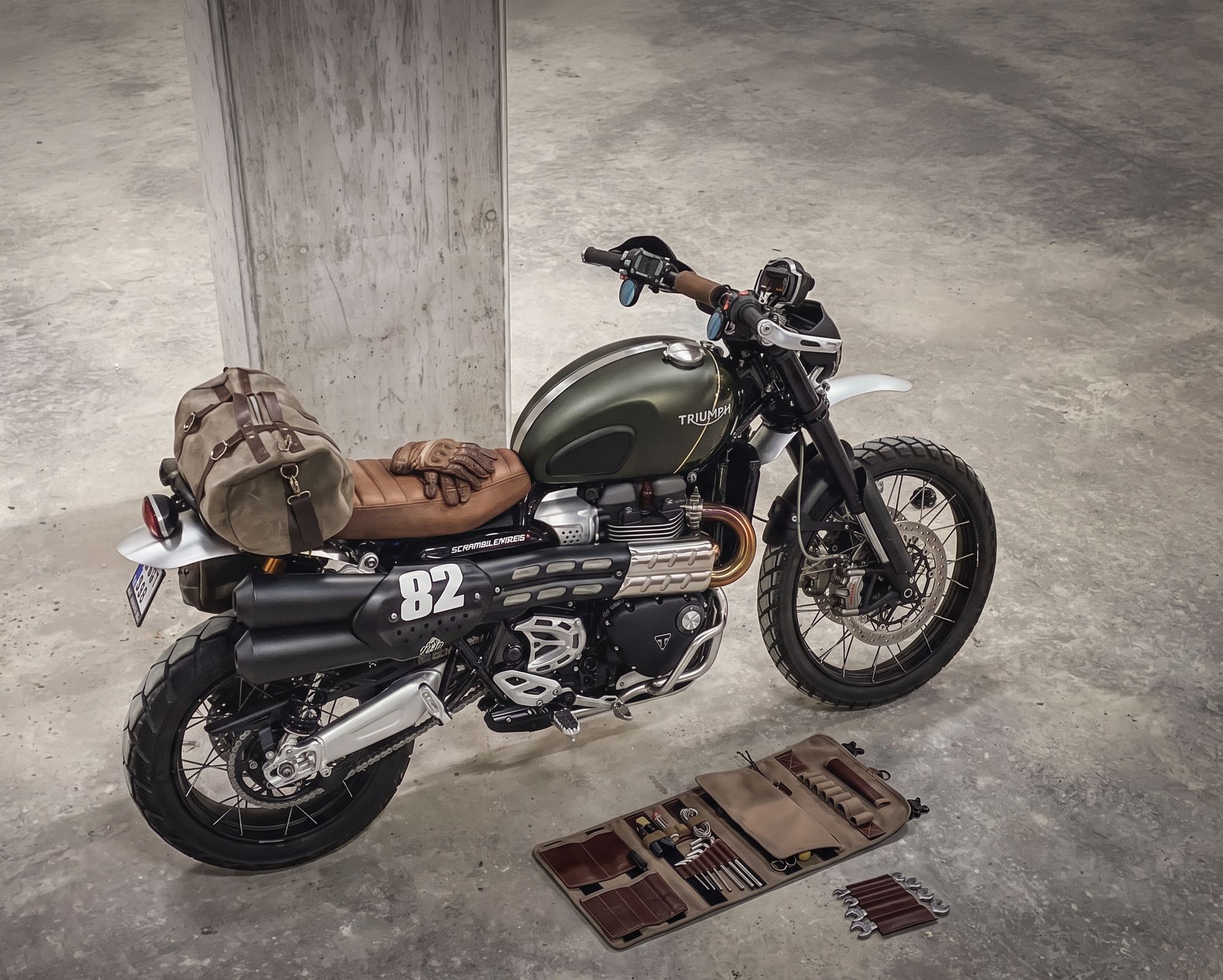 Motorcycle with the Nomad Shift roll and tools laid out on the floor
