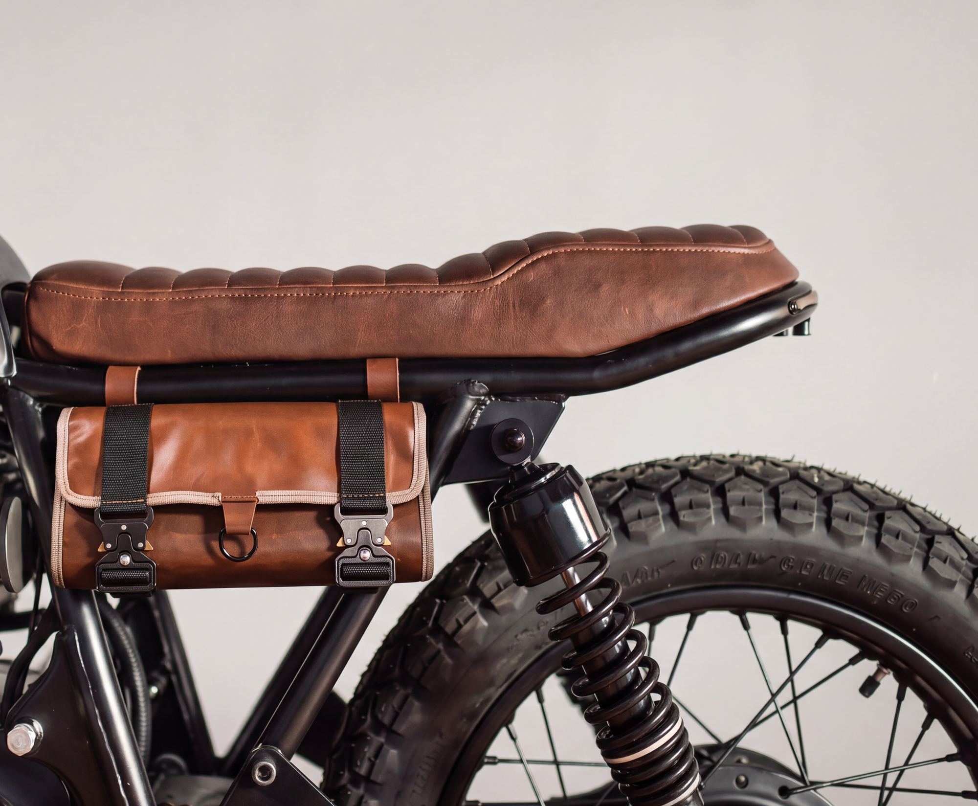 Leather tool roll strapped under a motorcycle seat